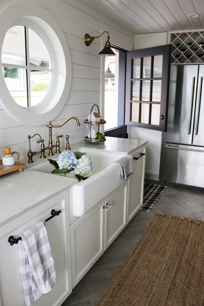 https://theinspiredroom.net/wp-content/uploads/2017/02/The-Inspired-Room-Small-Kitchen-Reveal-Farmhouse-Sink-Brass-Faucet-Navy-Dutch-Door.jpg