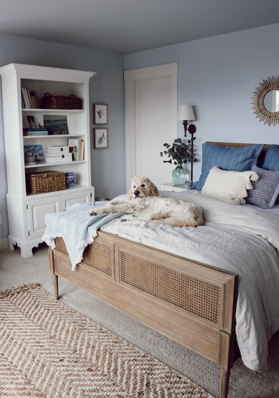 https://theinspiredroom.net/wp-content/uploads/2022/01/bedroom-decorating-blue-walls-cane-bed-rattan-mirror-white-bookcase-the-inspired-room-beach-house.jpg