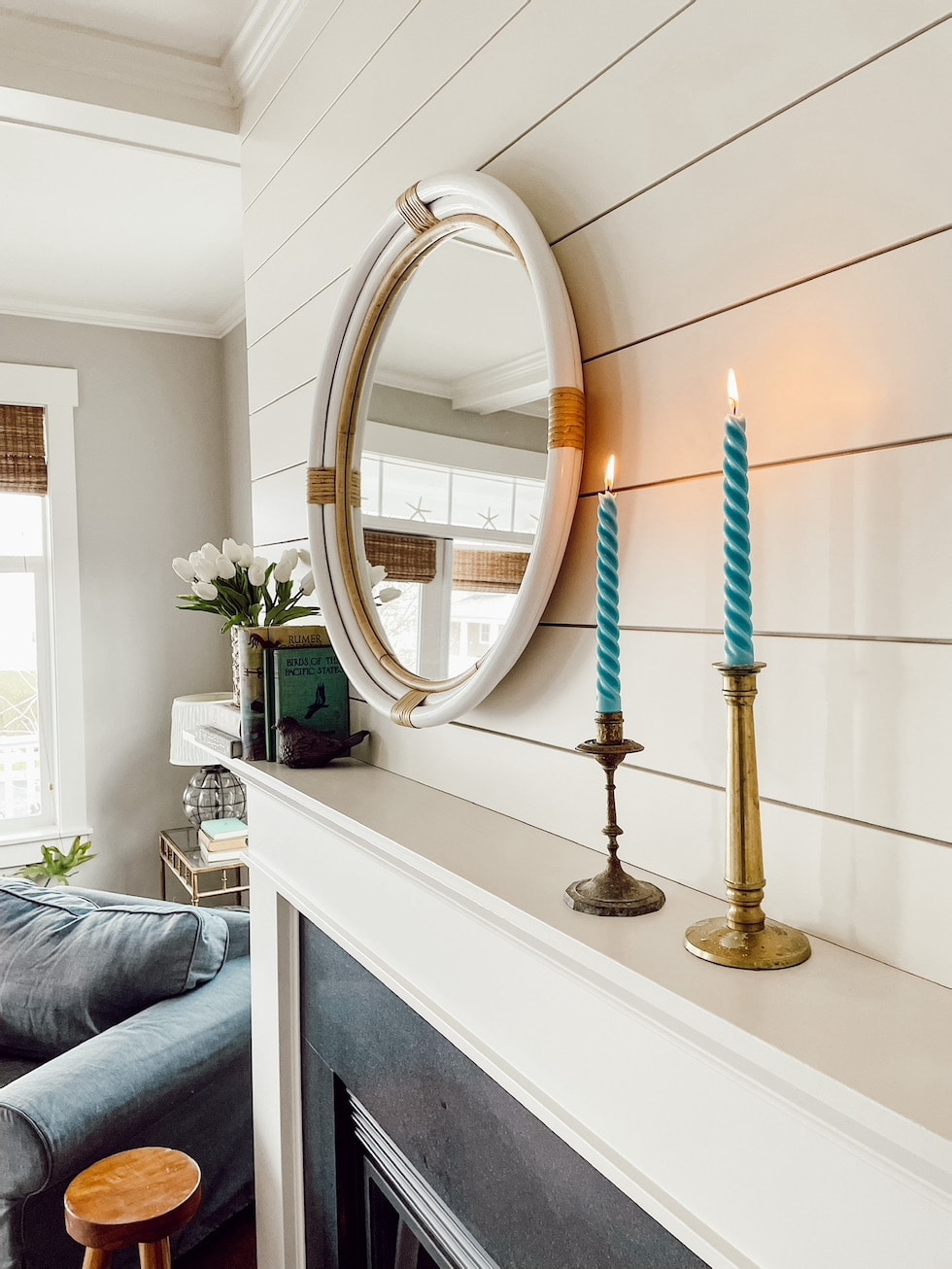 https://theinspiredroom.net/wp-content/uploads/2022/03/shiplap-fireplace-rattan-round-mirror-spiral-blue-candles-brass-candlesticks-the-inspired-room.jpg