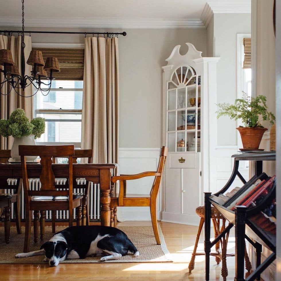 https://theinspiredroom.net/wp-content/uploads/2022/12/charming-dining-room-corner-hutch-glass-cabinets-wood-table-chandelier-woven-shades-cherrystreetblossoms.jpg